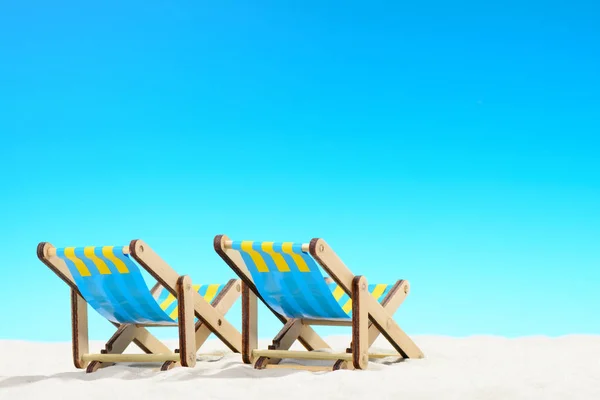 Twee ligbedden op het strand op de achtergrond van de blauwe hemel — Stockfoto