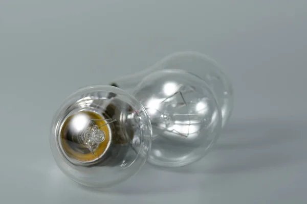 Três lâmpadas incandescentes em fundo cinza — Fotografia de Stock
