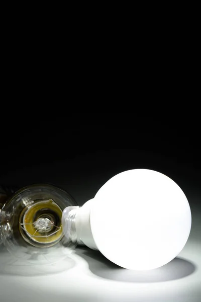 Glowing led lamp and incandescent bulb in the dark — Stock Photo, Image