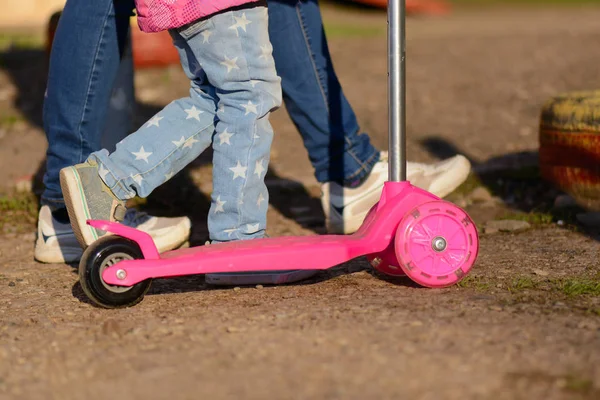 Una bambina con mia madre cavalca uno scooter — Foto Stock