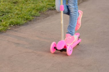 Scooter süren küçük kız.