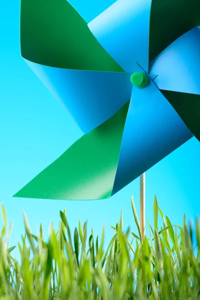 Windmill toy on green grass against the sky — Stock Photo, Image