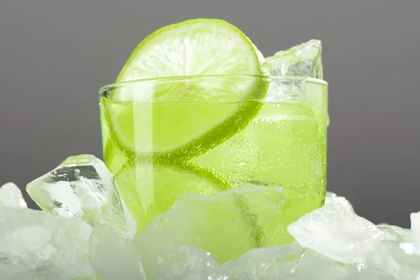 Un vaso de limonada con lima sobre hielo —  Fotos de Stock