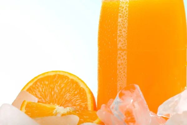 Бутылка апельсинового сока на льду — стоковое фото