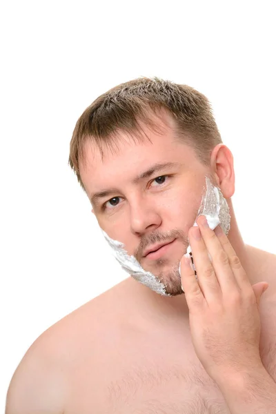 Człowiek ściera jego twarzy z kremem do golenia — Zdjęcie stockowe