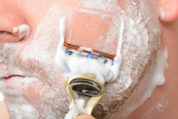 A man shaves on a white background — Stock Photo, Image