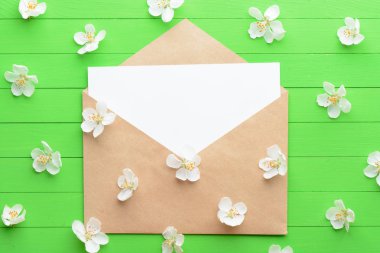 Yeşil ahşap arka plan üzerinde zarf ile boş kağıda