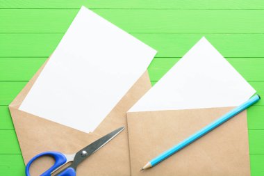 Yeşil ahşap arka plan üzerinde zarf ile boş kağıda