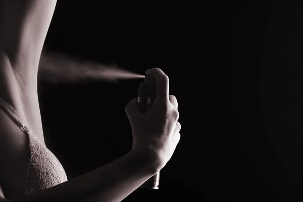Женщина распыляет дезодорант — стоковое фото