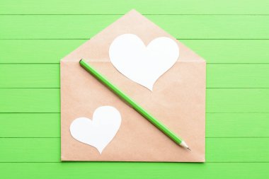 Yeşil ahşap zemin üzerinde bir zarf içinde bir kalp şeklinde beyaz etiket