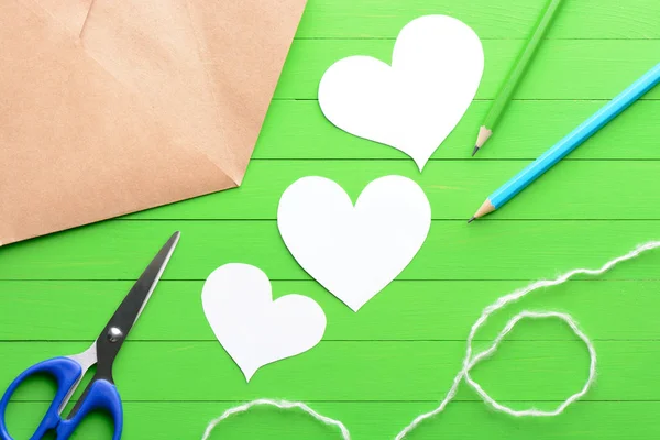 Klistermärken i form av ett hjärta med ett kuvert på grön trä bakgrund — Stockfoto