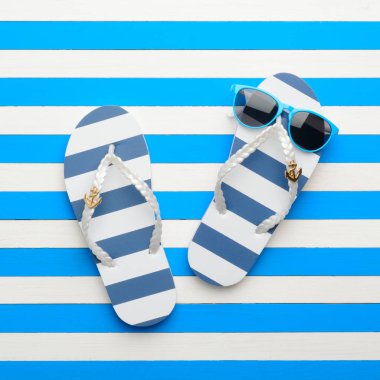 Çizgili şeylleri ve mavi-beyaz arka plan içinde güneş gözlüğü. Üstten Görünüm, düz yatıyordu.