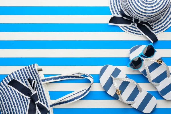 Beach accessories on a blue and white background. Top view, flat lay.