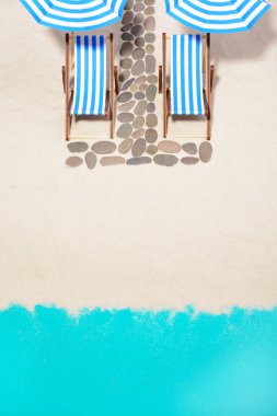 Şemsiye ve yolu taşlarının altında plaj mobilya