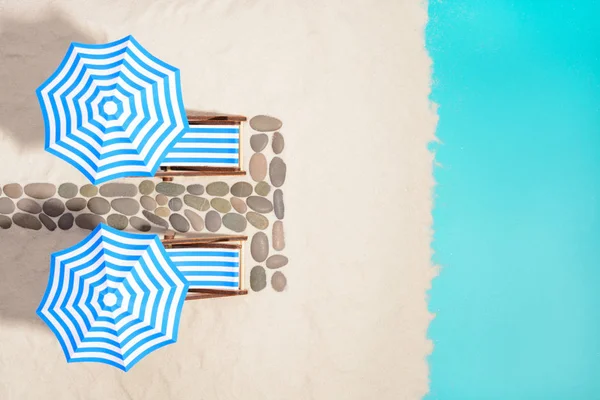 Şemsiye ve yolu taşlarının altında plaj mobilya