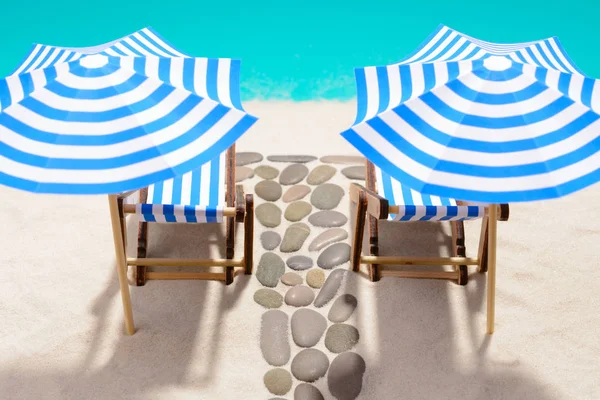 Şemsiye ve yolu taşlarının altında plaj mobilya