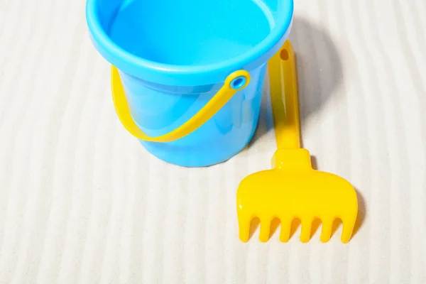Bucket with rake on sand — Stock Photo, Image