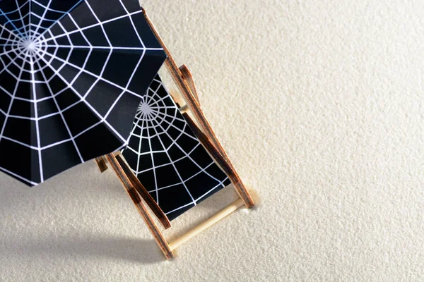 From above lounge chair and umbrella with spider web on sand — Stock Photo, Image