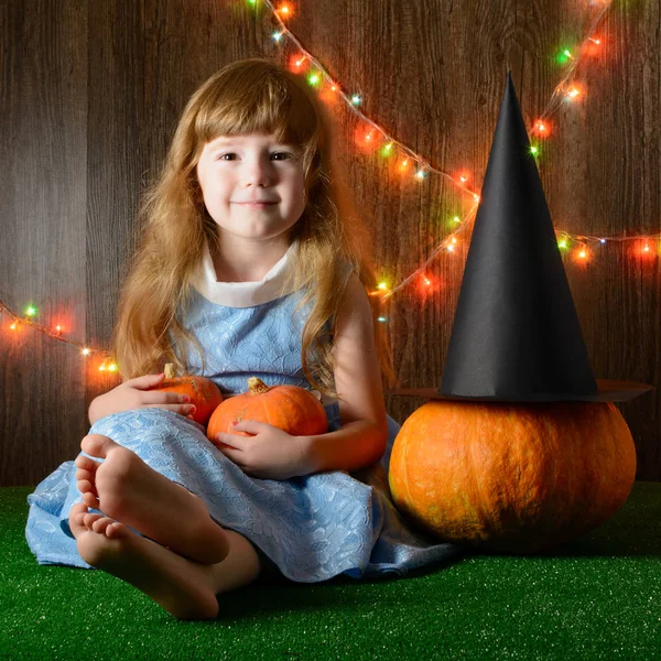 Ung flicka Halloween hatt hålla pumpa — Stockfoto
