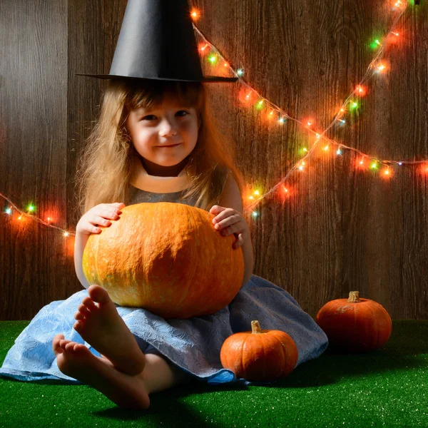 Ung flicka Halloween hatt hålla pumpa — Stockfoto