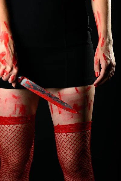 Mujer vistiendo medias rojas sosteniendo cuchillo sangriento — Foto de Stock