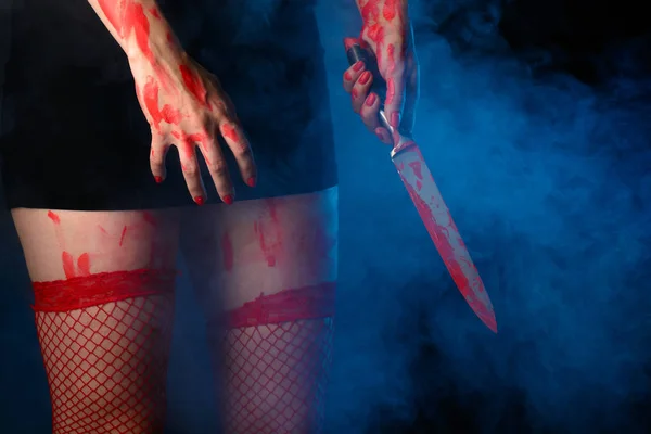 Mujer de pie con cuchillo ensangrentado en la mano — Foto de Stock