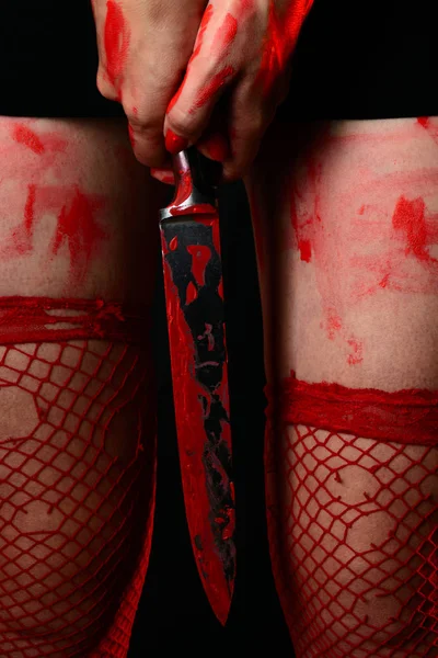 Mulher usando meias vermelhas segurando faca sangrenta — Fotografia de Stock