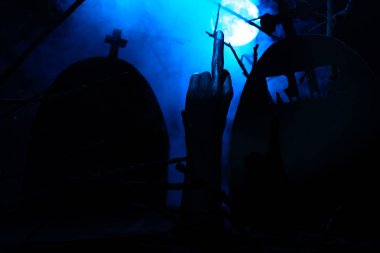 Ölü mezar taşları ve dolunay siste ortasında kol bok gösterir