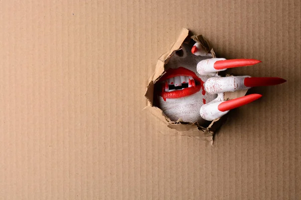 Vampiro rasgando através de papelão com garras afiadas — Fotografia de Stock