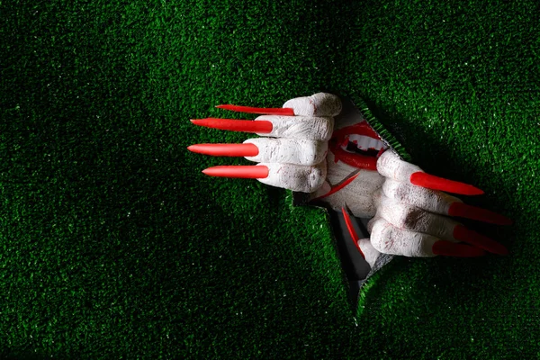 Halloween vampire tearing through turf with claws — Stock Photo, Image