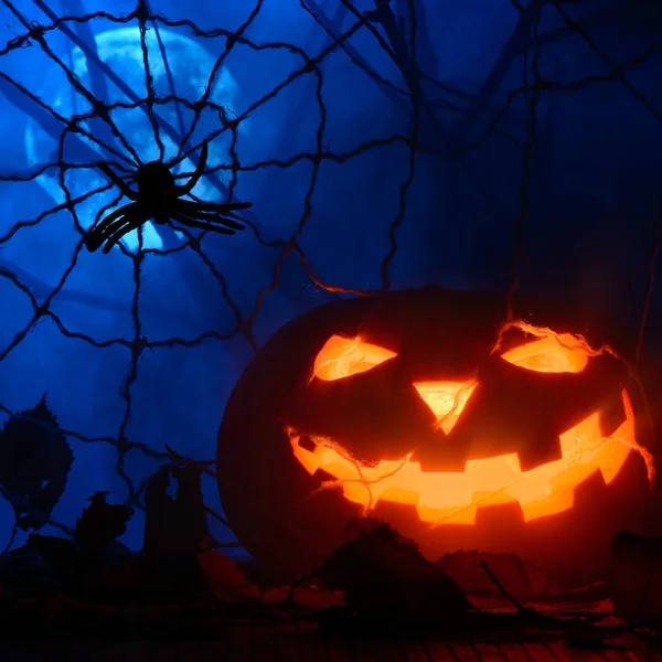 Horrible calabaza de Halloween en el fondo de la web y la luna llena en la niebla —  Fotos de Stock