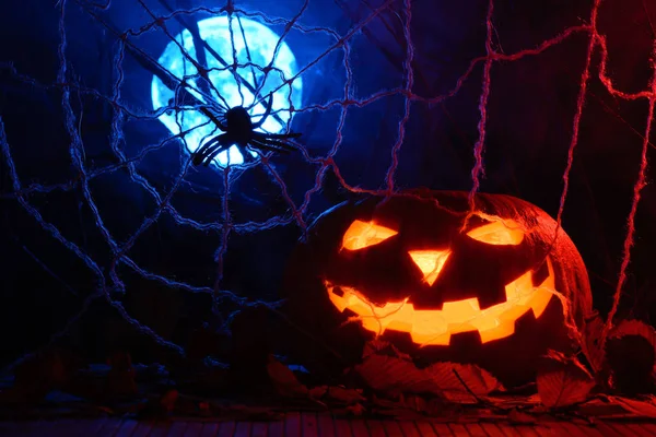 Hemsk Halloween pumpa i bakgrunden av webben och fullmåne — Stockfoto