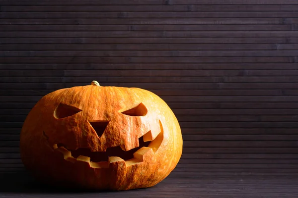 Halloween pompoen met eng gezicht op de achtergrond van houten latten — Stockfoto