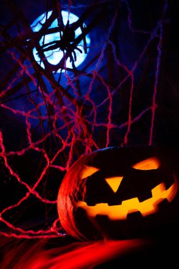 Korkunç Cadılar Bayramı Balkabağı parlayan bir yüz ve bir örümcek ağı ile dolunay siste arka plan üzerinde bir örümcek ile