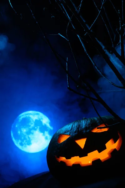Strašidelné Halloween dýně s zářící tváří na pozadí úplněk v mlze — Stock fotografie