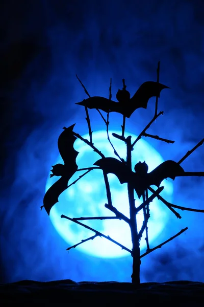 Tres murciélagos en el árbol, la luna llena en la niebla detrás — Foto de Stock