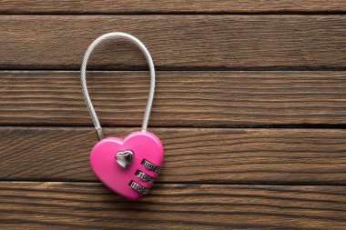 Ahşap arka plan üzerinde kalp şeklinde şifreli kilit