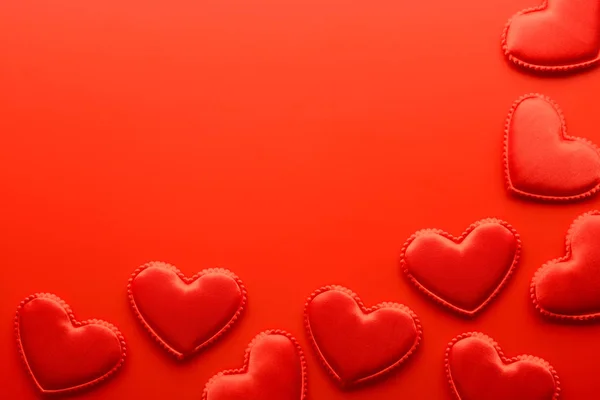 Маленькие сердца на красном фоне с копировальным пространством — стоковое фото