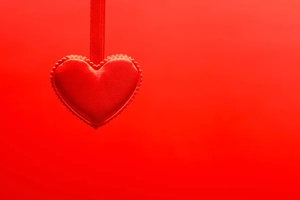 Маленькое красное сердце висит на ленте — стоковое фото