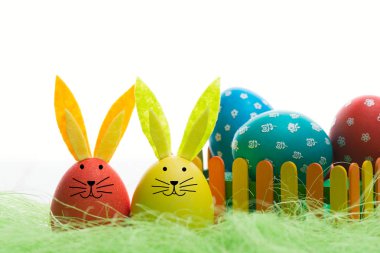 Yeşil sisal renkli bir çit arkasında Paskalya yumurta kulakları ile kompozisyon