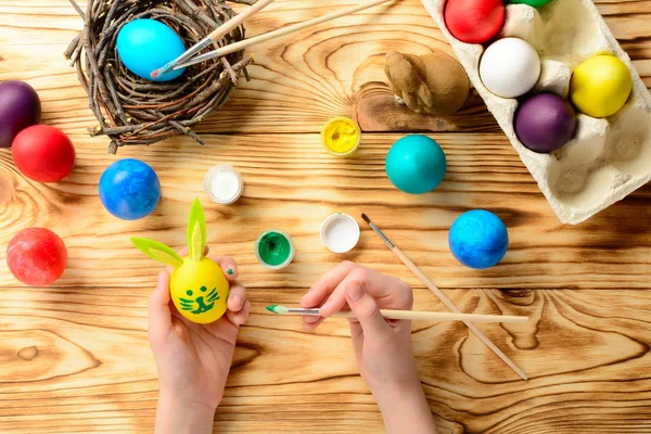 Easter concept. Child hands coloring eggs for Easter. Top view