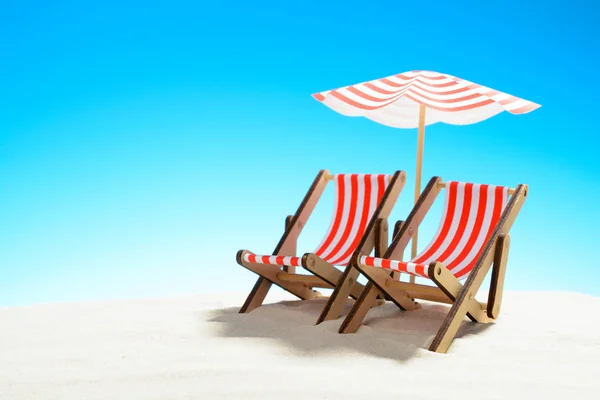Dos chaise longue bajo un paraguas en la playa de arena, cielo con espacio para copiar — Foto de Stock