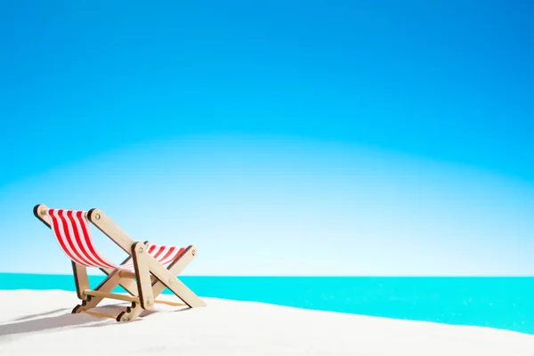 Tumbona en la playa de arena junto al mar y el cielo con espacio para copiar — Foto de Stock
