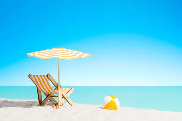 Sillón con sombrilla y pelota de playa en la costa — Foto de Stock