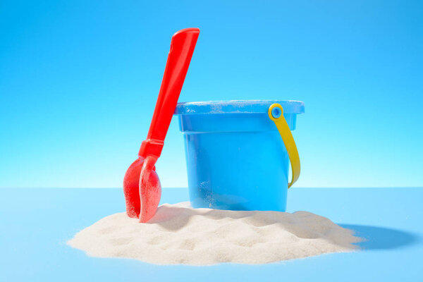 Toy plastic bucket and shovel in the sand