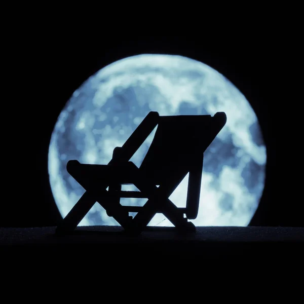 La silueta de una tumbona en el fondo de la luna llena — Foto de Stock