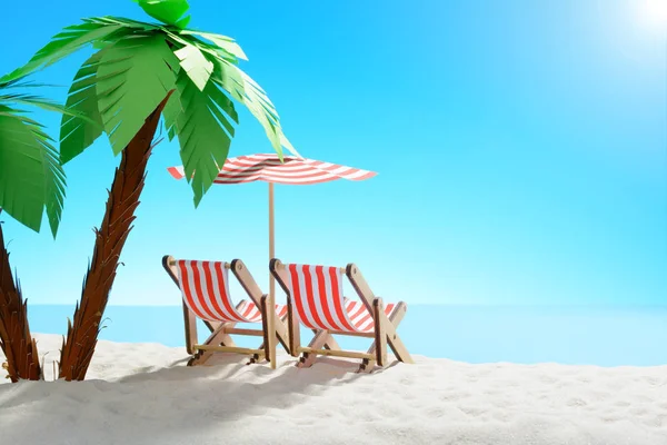Twee ligstoelen onder een palmboom aan de zandige kust. Hemel met kopie ruimte — Stockfoto
