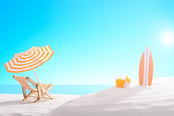 Tropikalne martwa. Świt nad zatoką. Leżak, piłkę i deskę surfingową na plaży — Zdjęcie stockowe
