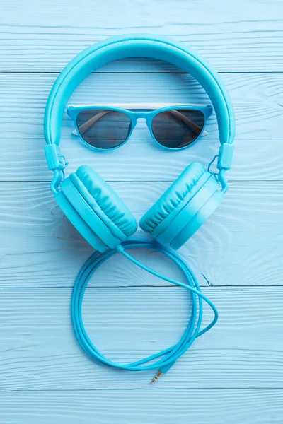 Jasny niebieski słuchawki i okulary przeciwsłoneczne — Zdjęcie stockowe