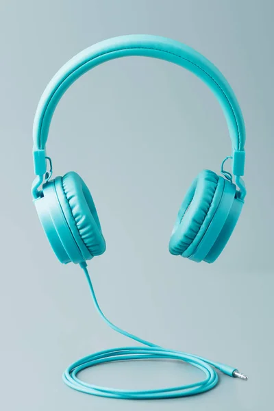 Světlé modrá sluchátka na šedé — Stock fotografie